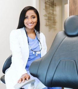 Dr-givan, female dentist in modern dental clinic wearing scrubs and lab coat, sitting beside dental chair, ready for patient consultation and oral care treatment